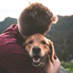 man hugging emotional service dog