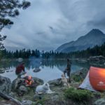 camping with dogs by a lake and mountains