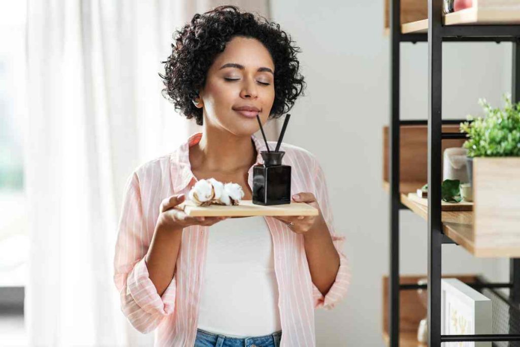 woman smelling essential oils from a diffuser